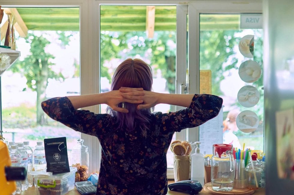 Woman Looking Out the Window in a Room With Well Designed Heating and Cooling System