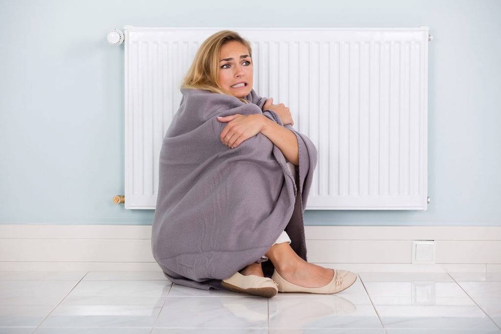Woman Sitting Near Gas Heater